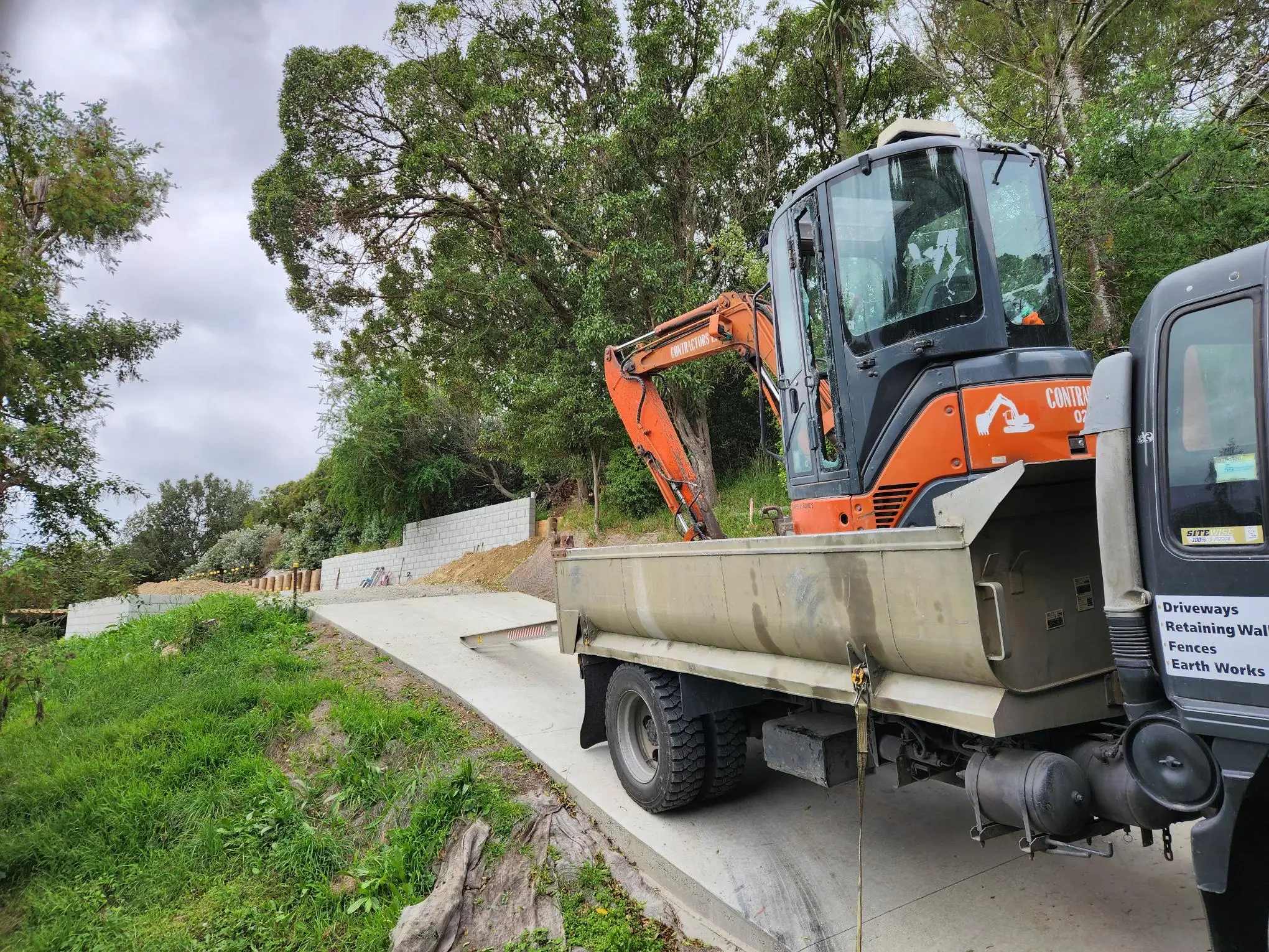 Digger and tipper on a retaining wall job in the Port Hills